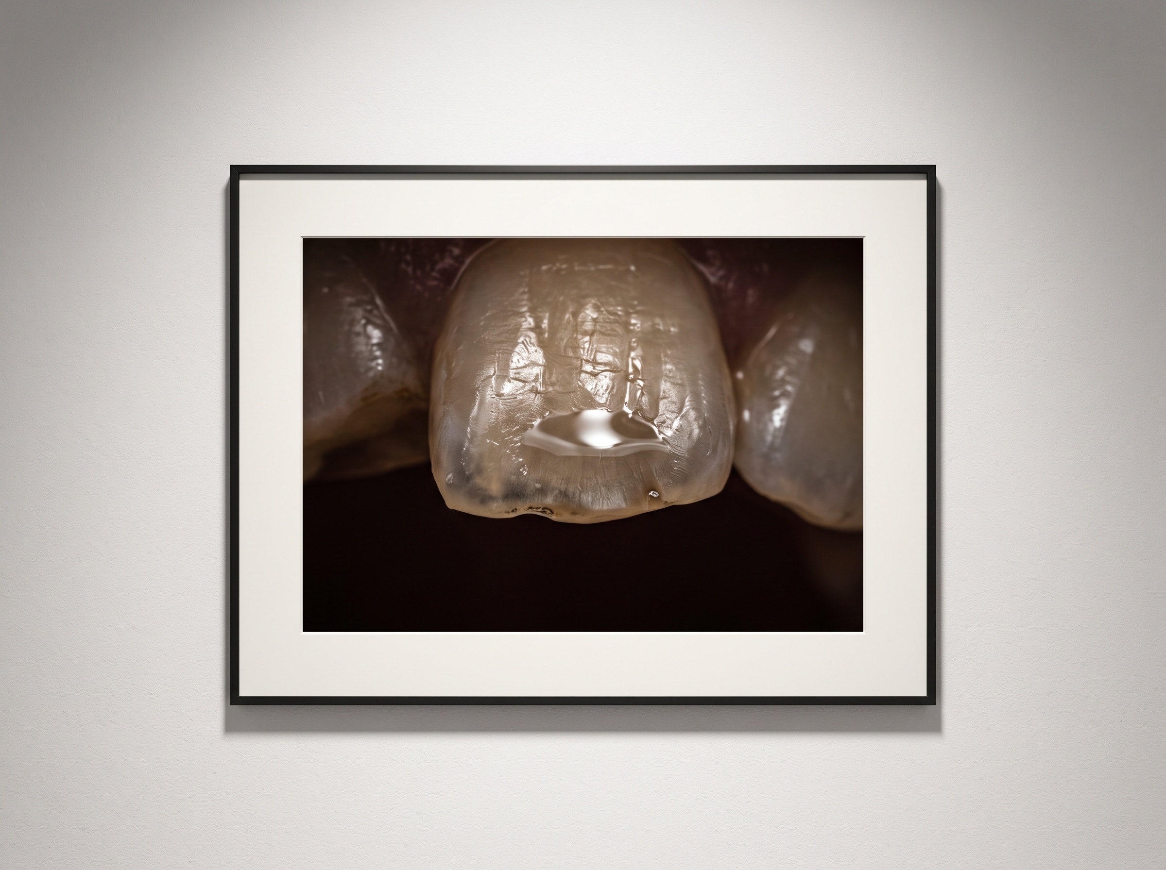 Macro of a saliva-wet incisal edge reflecting a mirror-like specular point of light
